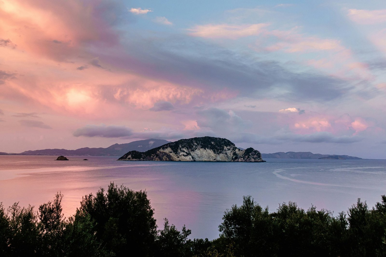 body of water near mountain during sunset