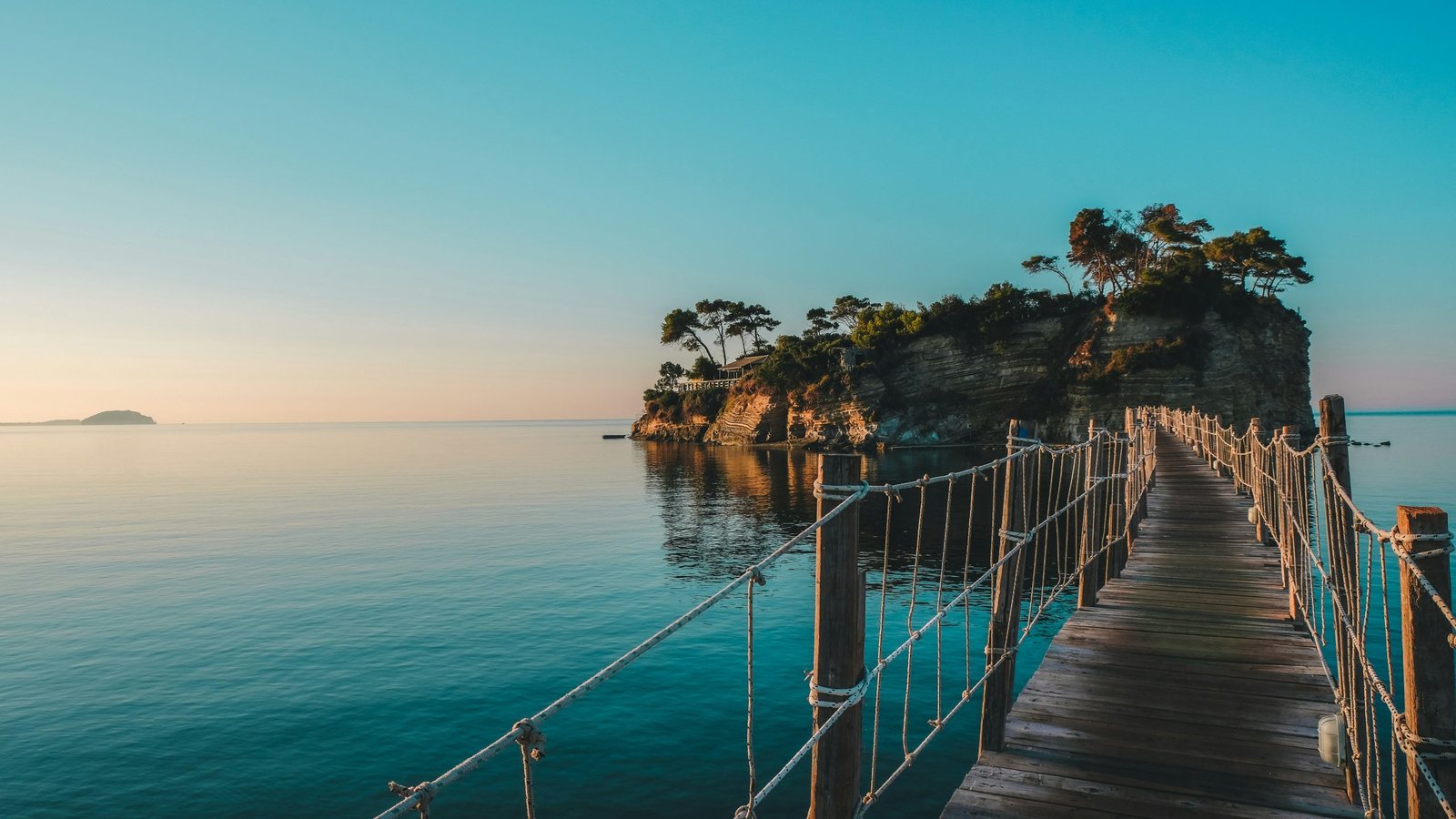 brown wooden dock on blue sea under blue sky during daytime